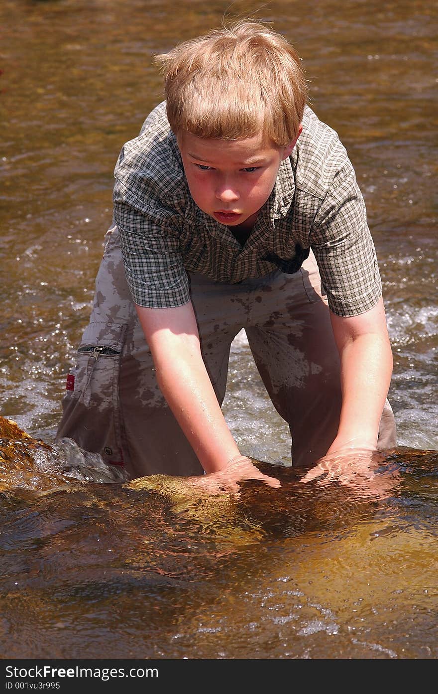 Boy plays in a cool creek on a hot summer day. Boy plays in a cool creek on a hot summer day