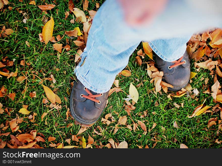 A woman's legs looking down in the fall leaves. A woman's legs looking down in the fall leaves