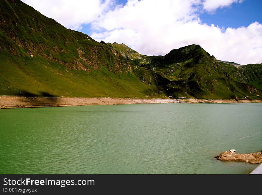 Clear lake amidst mountains below a sunny sky. Clear lake amidst mountains below a sunny sky