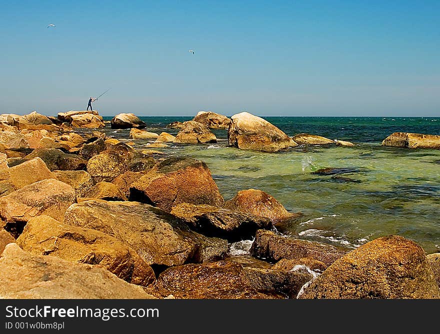 Sea view with fisherman and seagulls in the sky