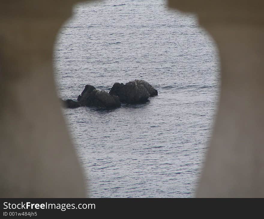 A view on the rocks through the marble fence. A view on the rocks through the marble fence