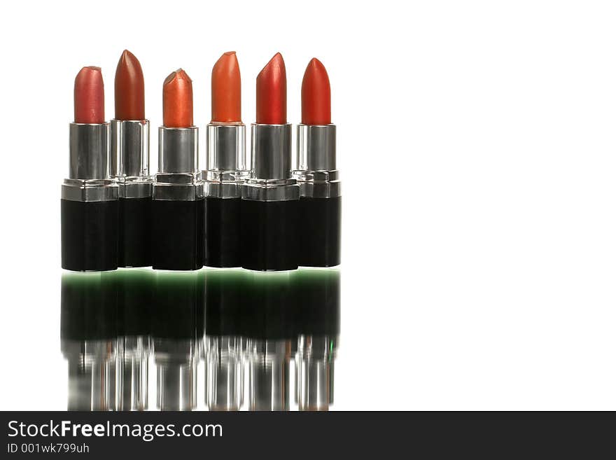 Bunch of lipsticks on white with reflection shot horizontal