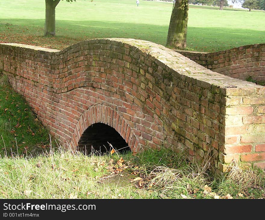 A red-brick bridge over a stream in the English countryside. A red-brick bridge over a stream in the English countryside.