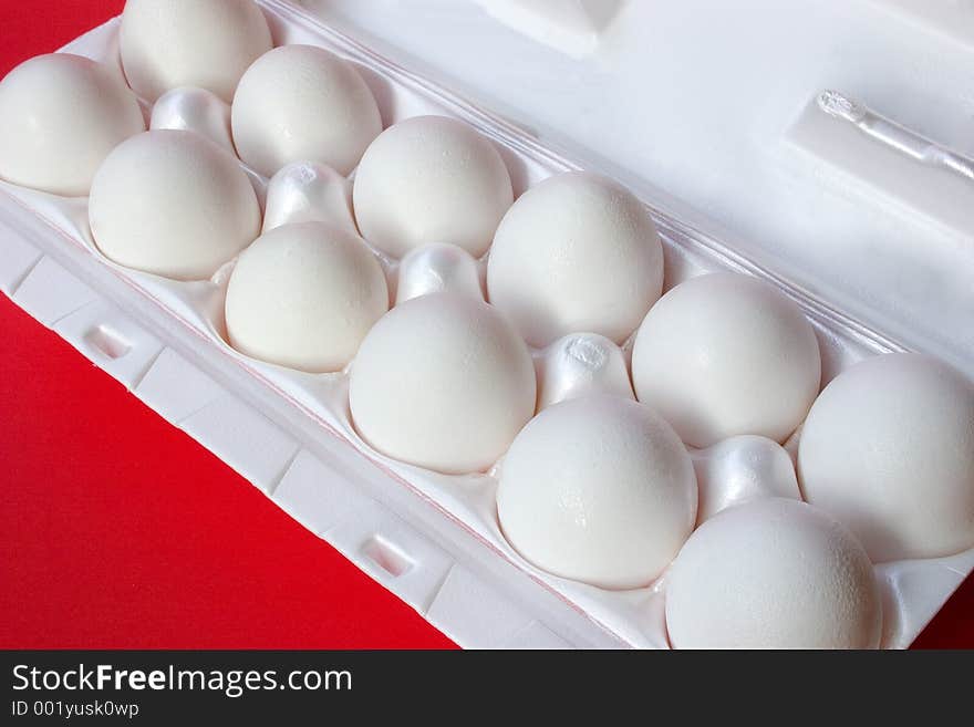 A dozen fresh eggs still in their carton. A dozen fresh eggs still in their carton