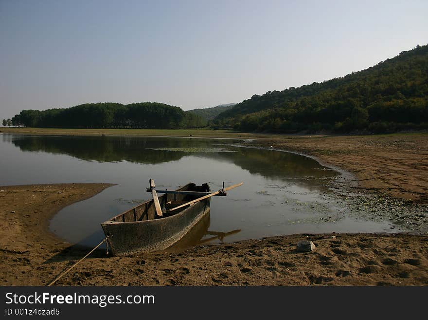 Lake with a boat and trees in the background. Lake with a boat and trees in the background