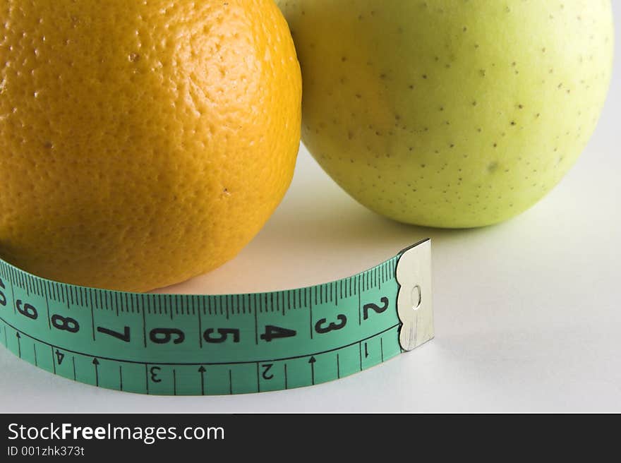 Apple, orange a tape isolated over white background. Apple, orange a tape isolated over white background