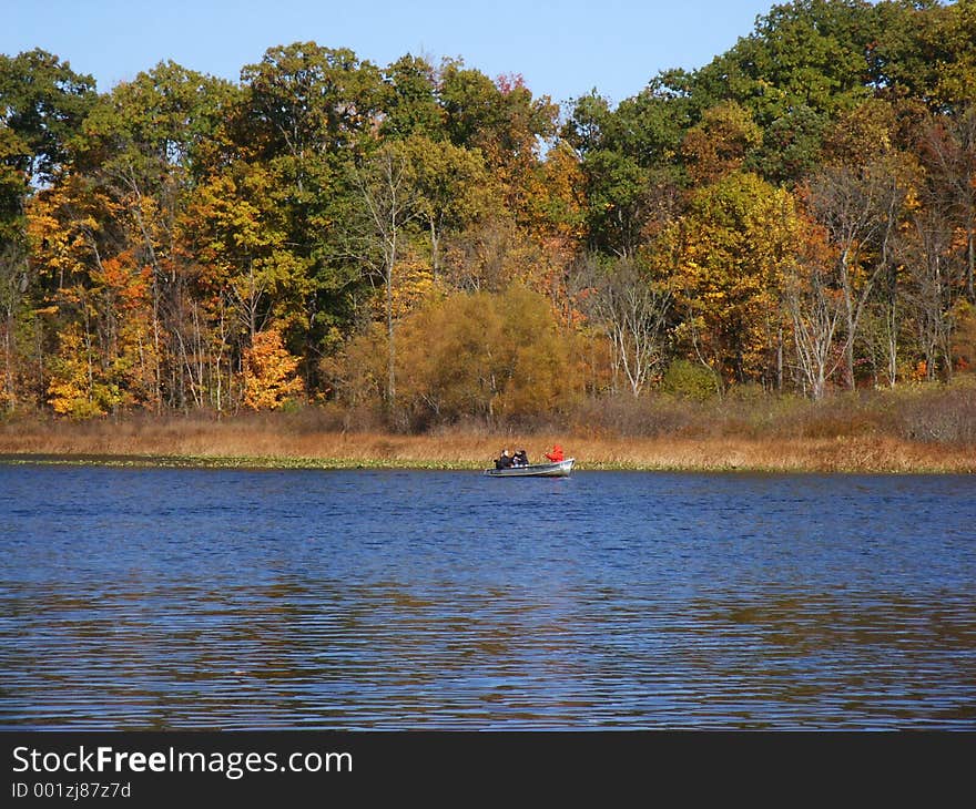 Autumn lake with rowboat on far side. Autumn lake with rowboat on far side