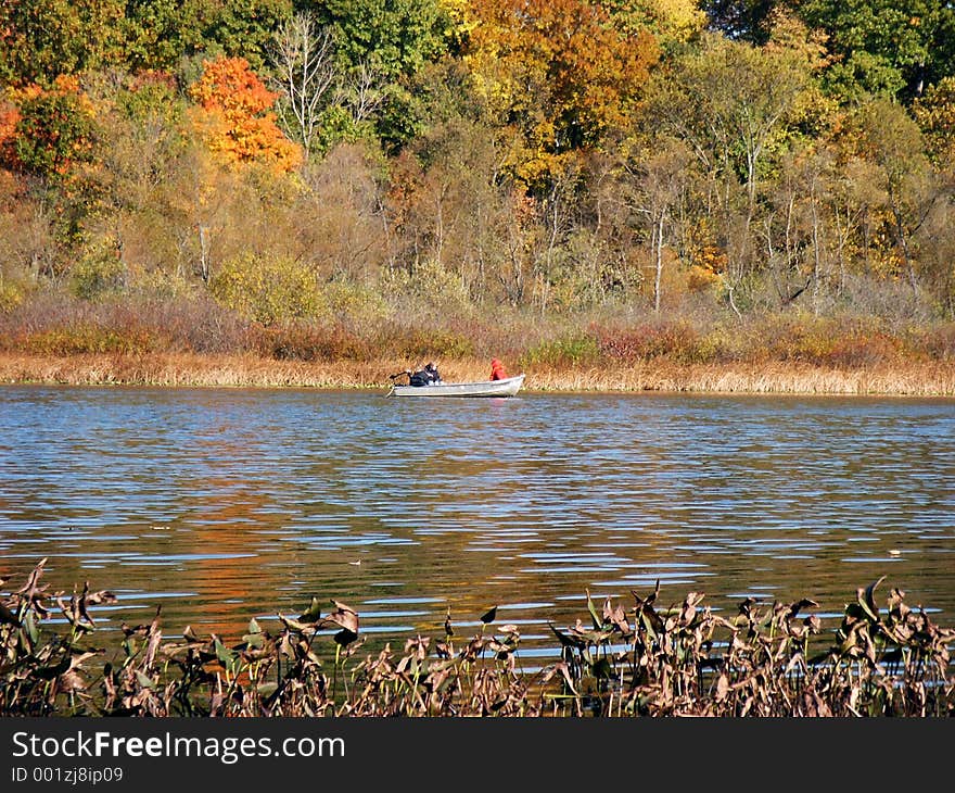 Rowboat across the lake against autumn backdrop. Rowboat across the lake against autumn backdrop