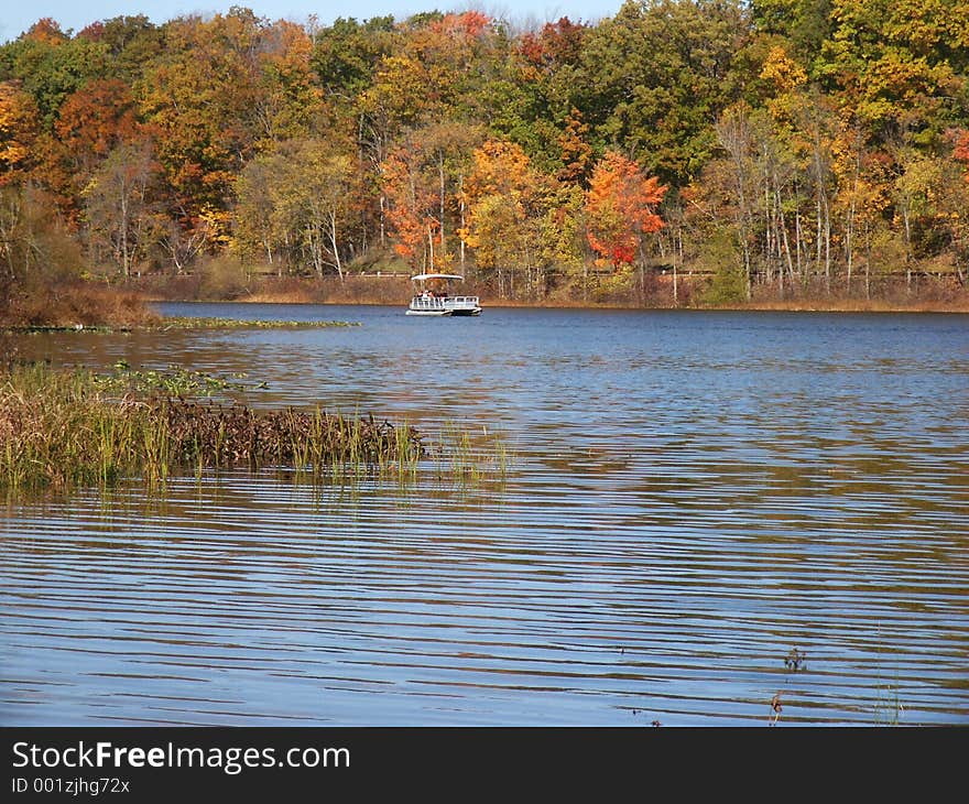 Pontoon boat approaching from far end of lake. Pontoon boat approaching from far end of lake