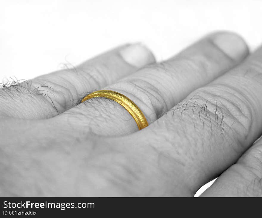 A (desaturated) hand with the wedding ring on a finger. A (desaturated) hand with the wedding ring on a finger