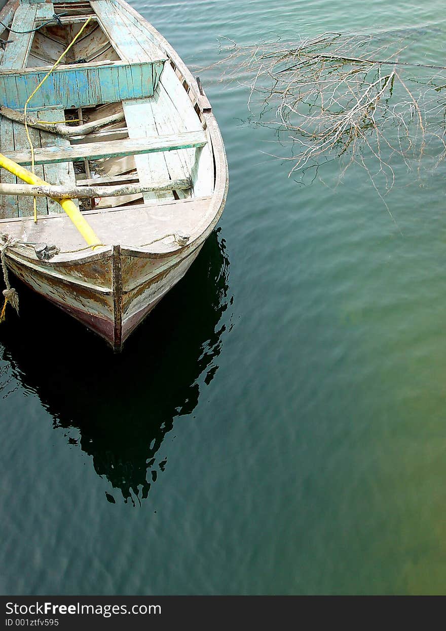 Old fishing boat casting reflections on the nile river in Egypt.