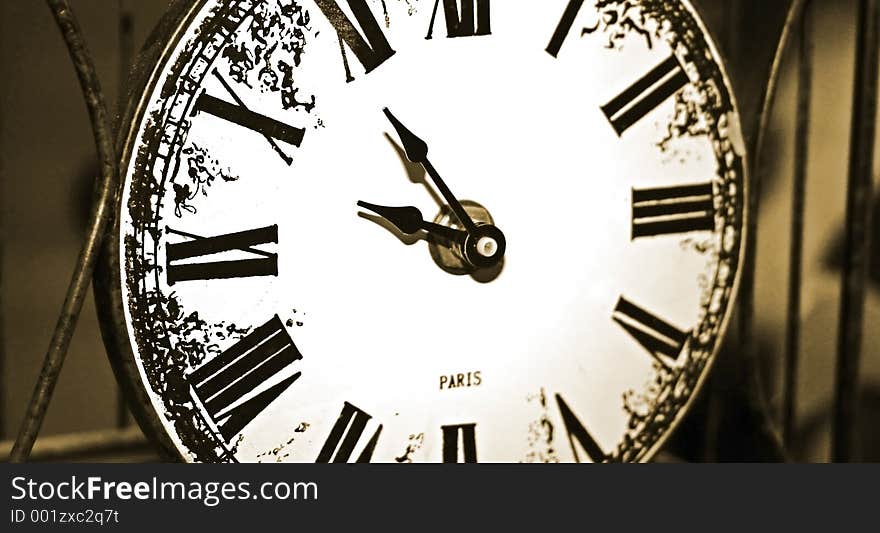 Photo of an antique clock within a metal frame. Photo of an antique clock within a metal frame