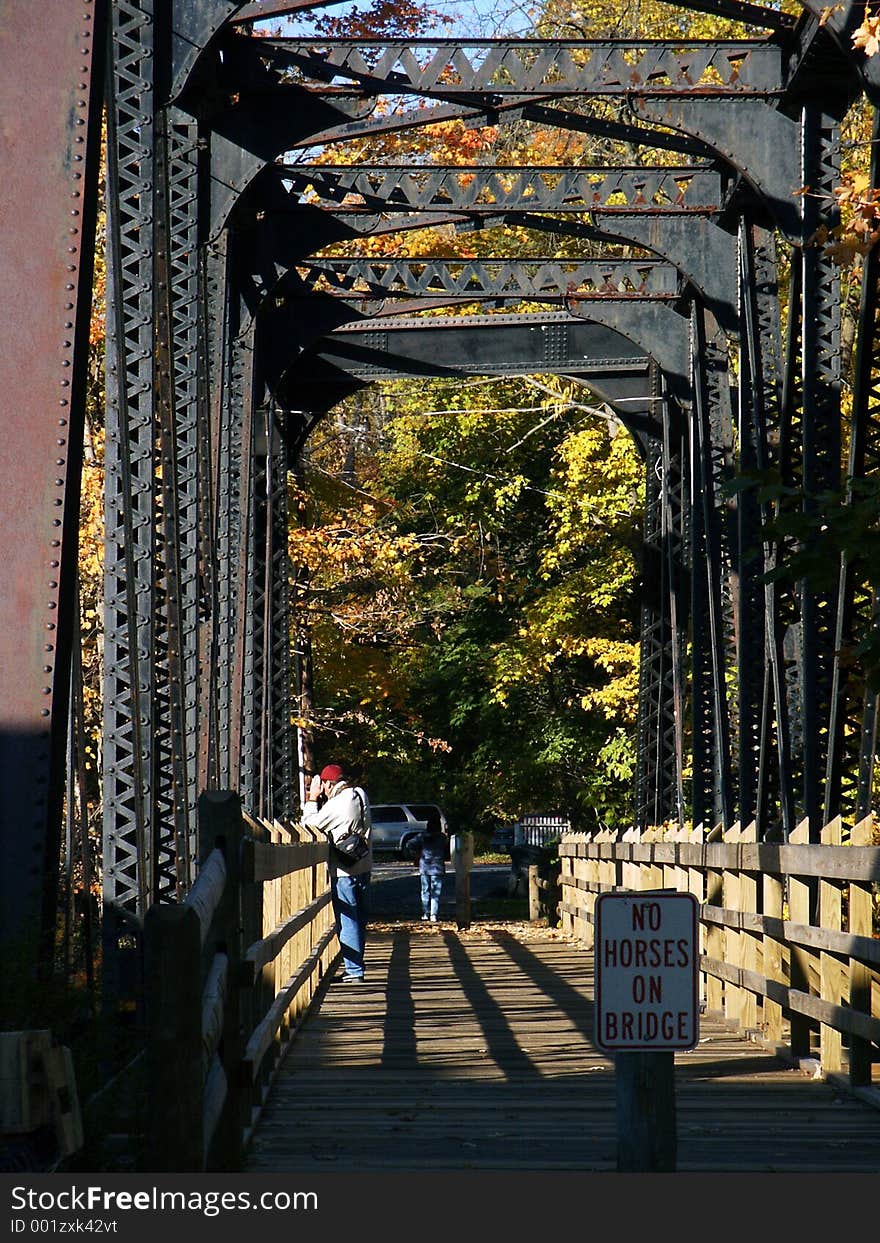 Photographer shooting from old steel-truss pedestrian bridge. Photographer shooting from old steel-truss pedestrian bridge