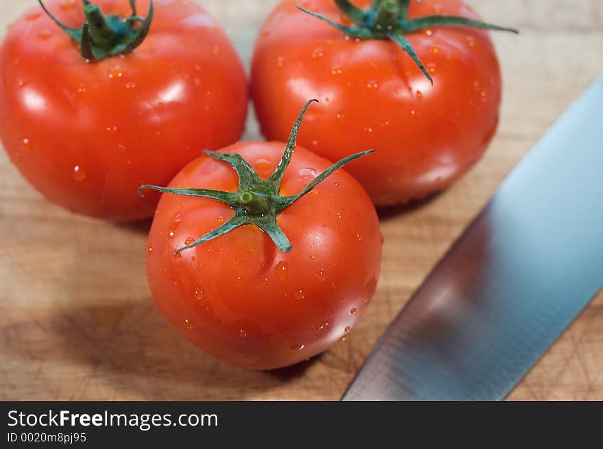 Red, ripe tomatoes on cutting board with knife. Red, ripe tomatoes on cutting board with knife