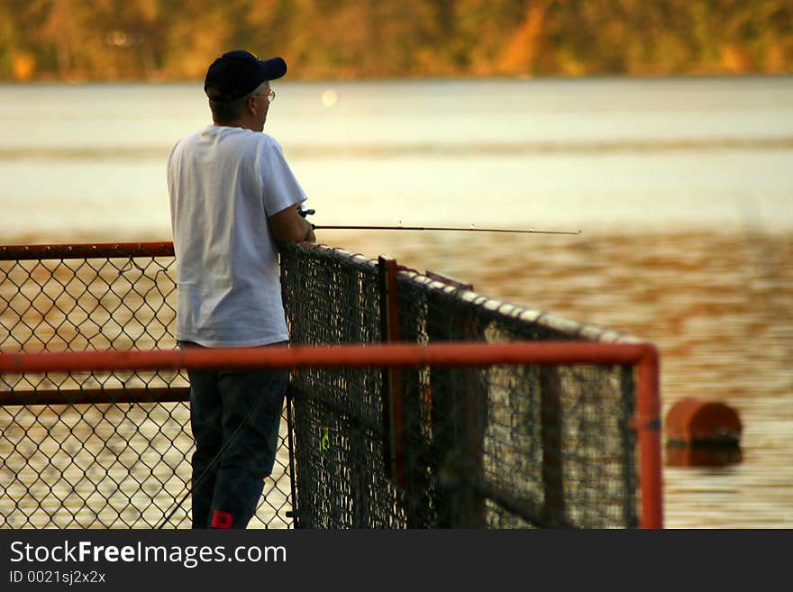 Man fising from dam platform on llake. Man fising from dam platform on llake