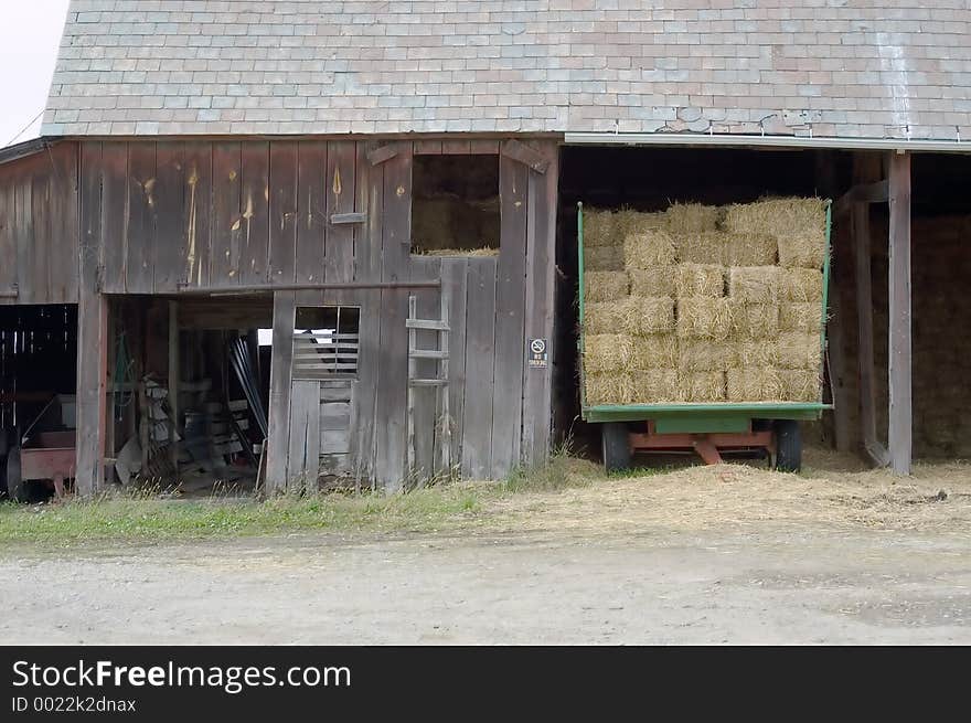 A barn with trailor, still loaded with hay. A barn with trailor, still loaded with hay