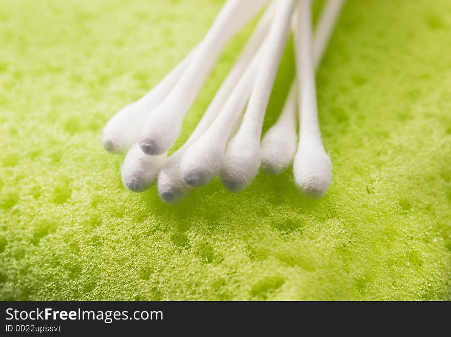 Cotton sticks ona green sponge. Cotton sticks ona green sponge