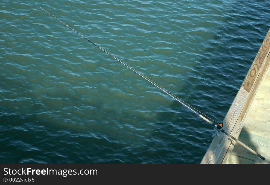 A fishing pole on a fishing pier.