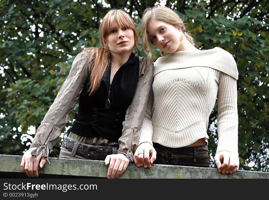 girlfriends smiling from a balcony