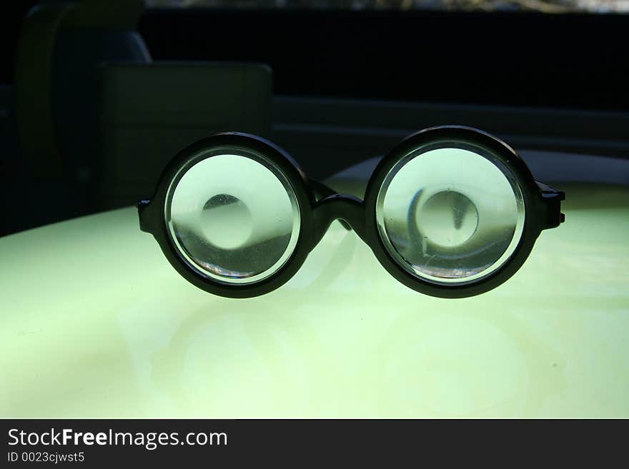 Glowing joke spex on bright surface with rather dark background. Glowing joke spex on bright surface with rather dark background