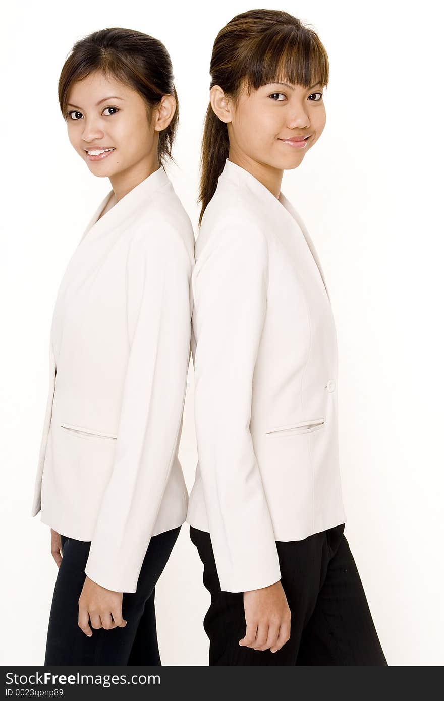 Two attractive young asian women in matching white jackets. Two attractive young asian women in matching white jackets