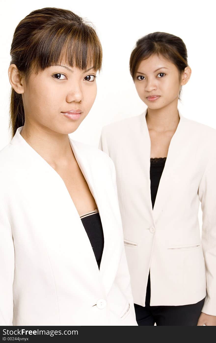 Two pretty asian women in matching business suits. Two pretty asian women in matching business suits