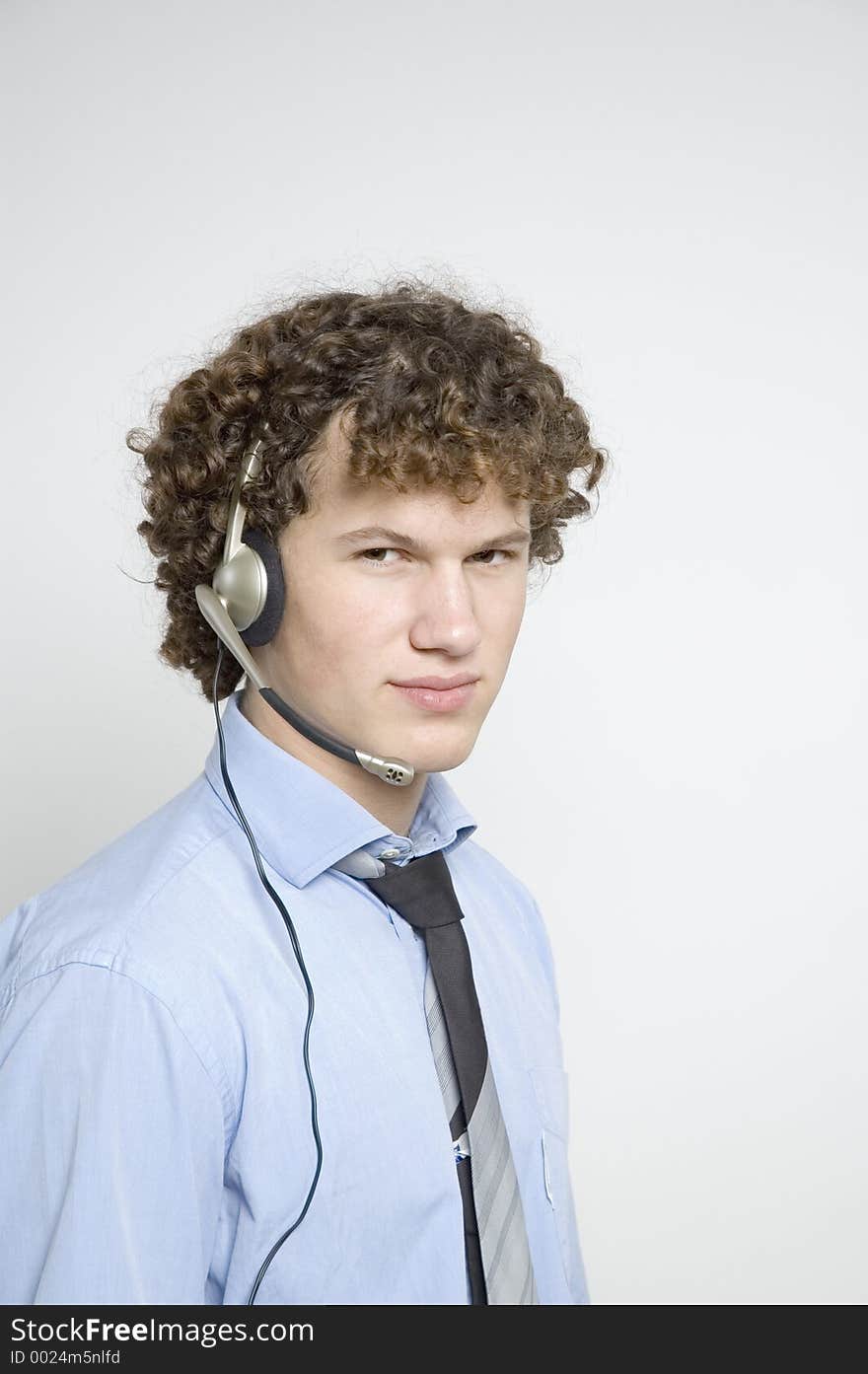 Boy in relaxed business attire wearing a telephone headset. Boy in relaxed business attire wearing a telephone headset.