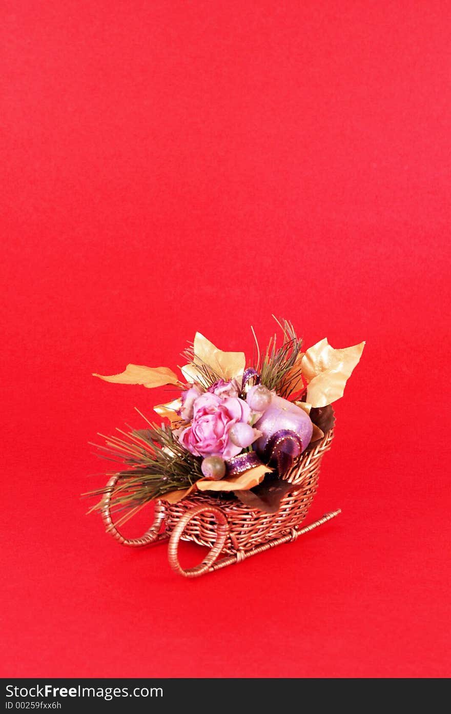 Artificial flowers in a sleigh on red background with space for copy. Artificial flowers in a sleigh on red background with space for copy.