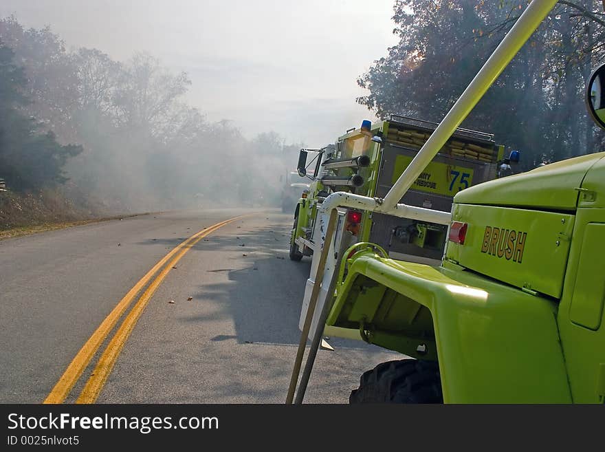 Fire tenders parked on highway while fighting bush fire