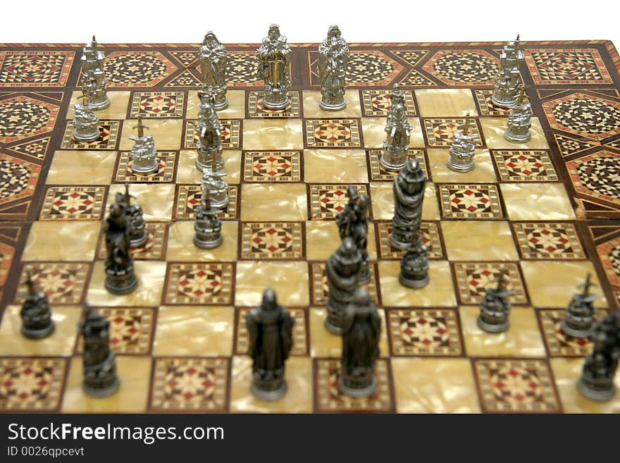 Antique wooden and 'mother of pearl' chess board with pewter chess pieces on it.