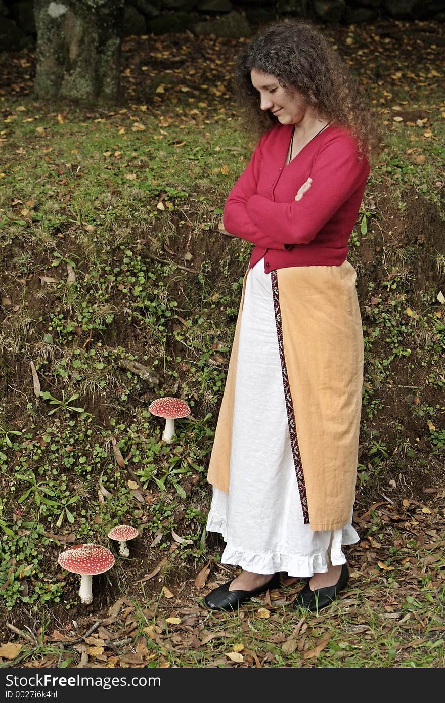 Mushroom lady watching fly agaric poisonous mushrooms in field