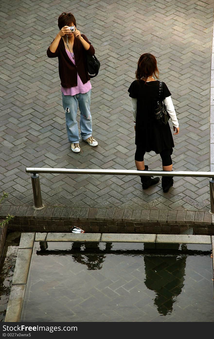 A young boy is taking a picture of his girlfiend. A young boy is taking a picture of his girlfiend