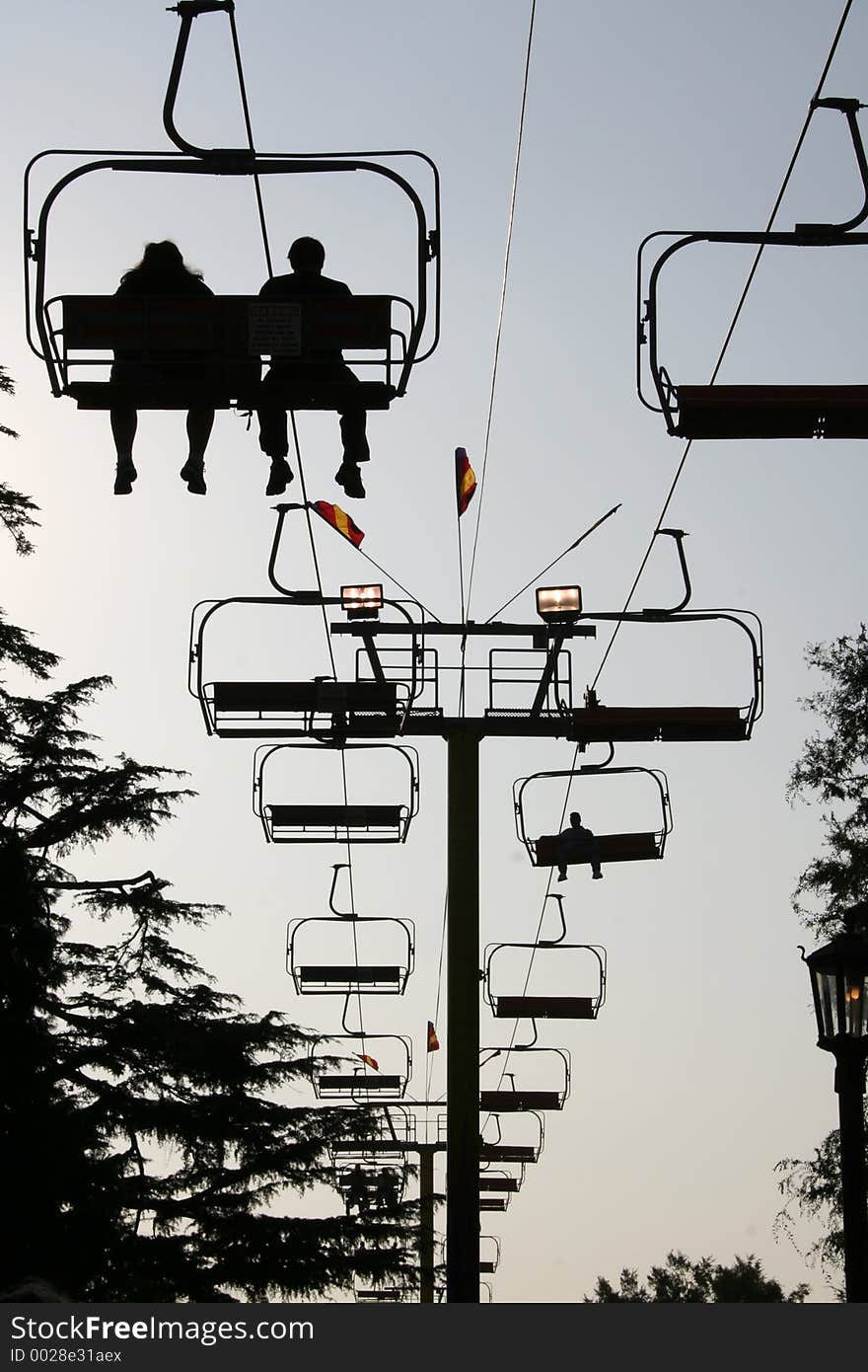 Silhouette of people on the ski lift ride at the county fair. Silhouette of people on the ski lift ride at the county fair