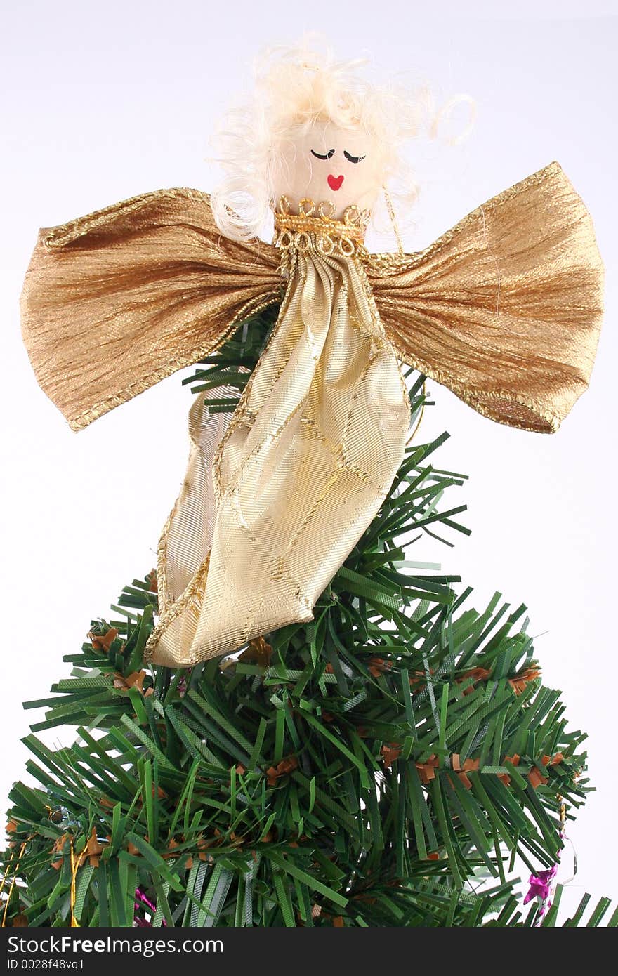 Gold Angel on top of a xmas tree with white background. Gold Angel on top of a xmas tree with white background