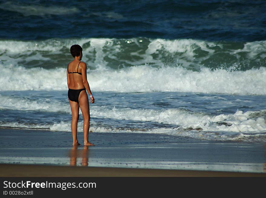 Older woman standing looking at the sea. Older woman standing looking at the sea