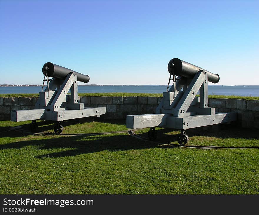 A pair of vintage military cannons facing the sea. A pair of vintage military cannons facing the sea.