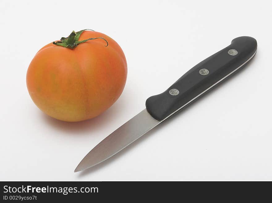 Tomato and knife in a white background