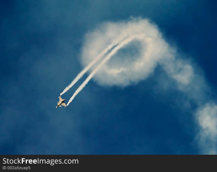 Jetfighter plane flying loops with plume of smoke. Jetfighter plane flying loops with plume of smoke