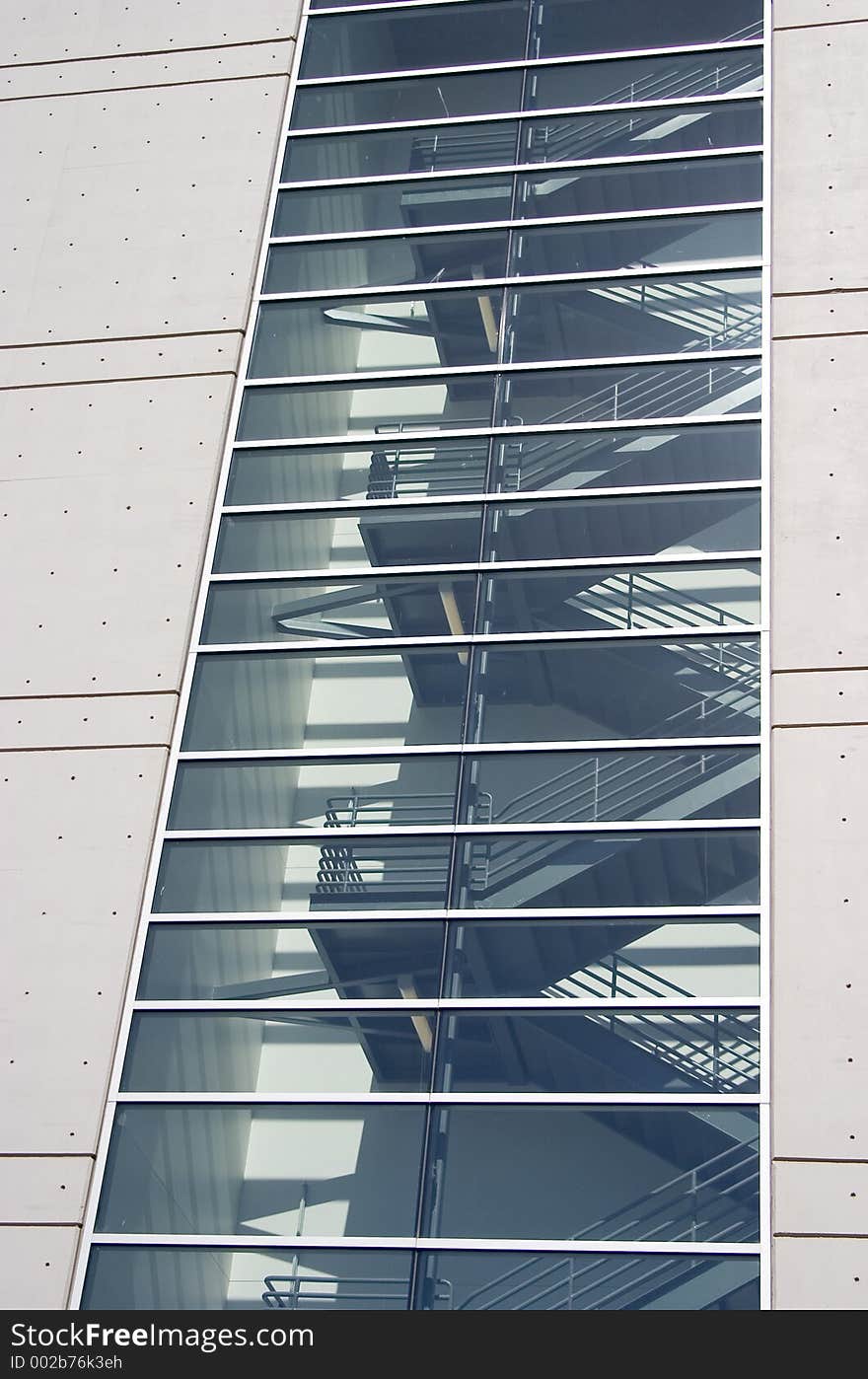 A modern stairway that looks like a fire escape behind glass. A modern stairway that looks like a fire escape behind glass.