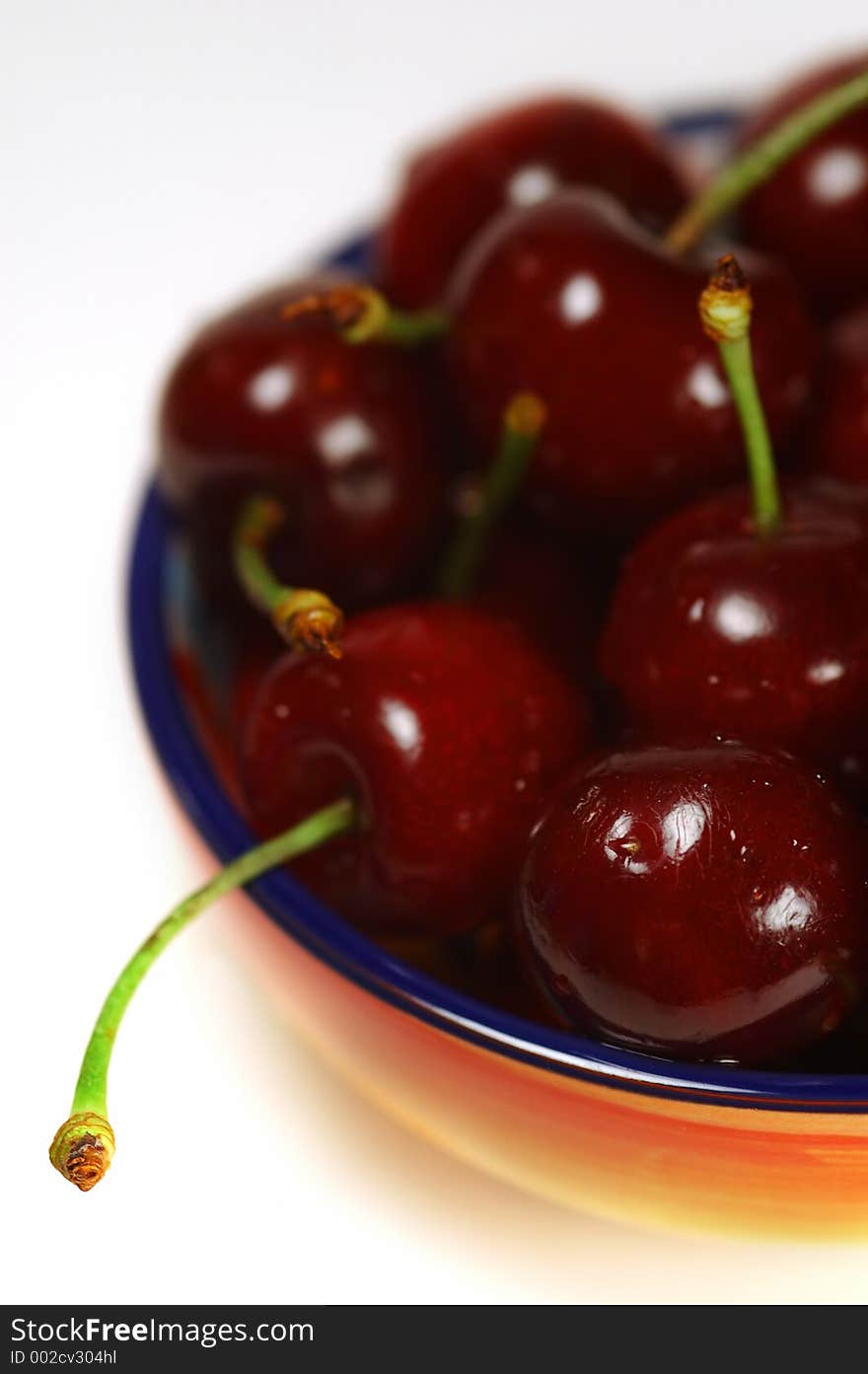 Ripe and juicy cherries in colorful bowl