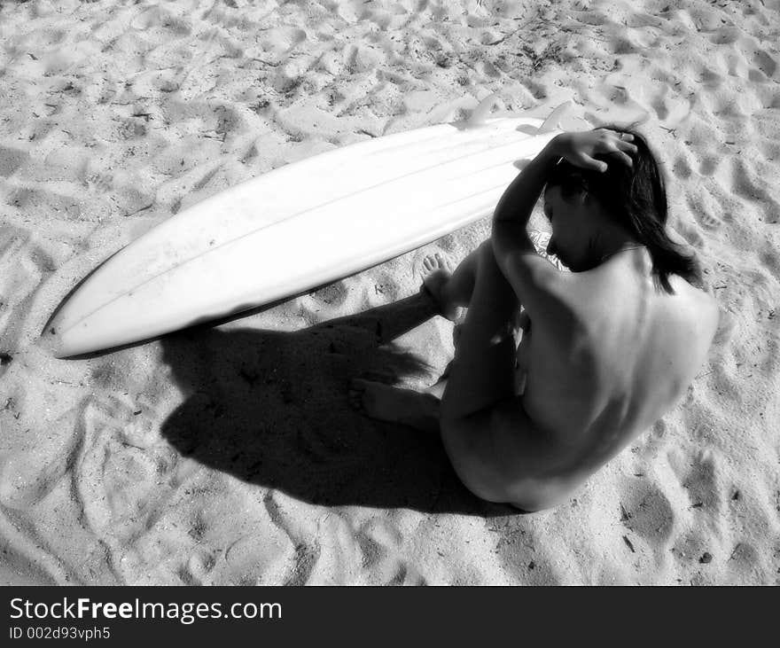 A lone female sits on the beach, considerign life. A lone female sits on the beach, considerign life.