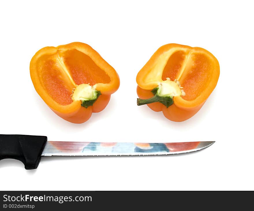 Tow half of orange bulgarian pepper over the white with knife. Tow half of orange bulgarian pepper over the white with knife