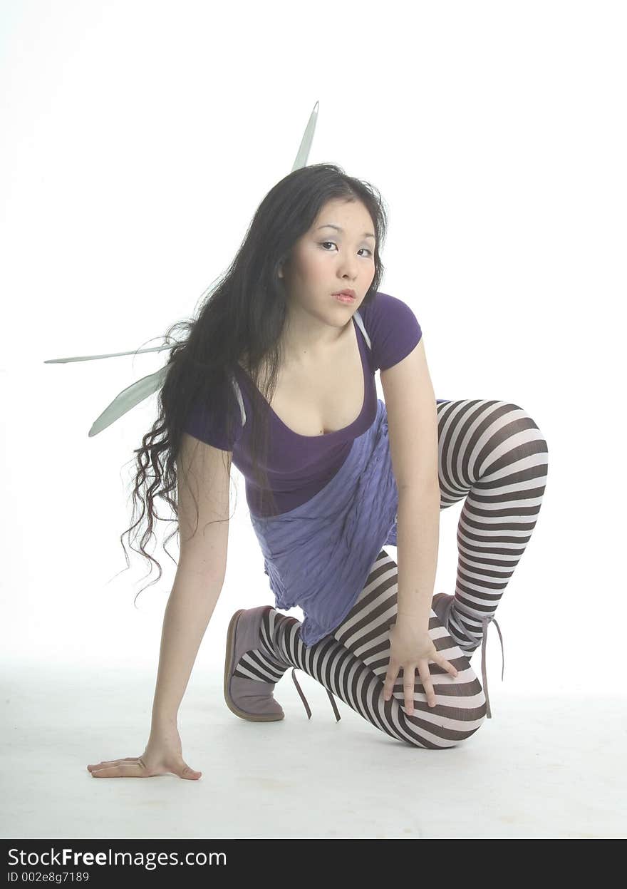 Pretty fairy in striped tights kneeling. Pretty fairy in striped tights kneeling