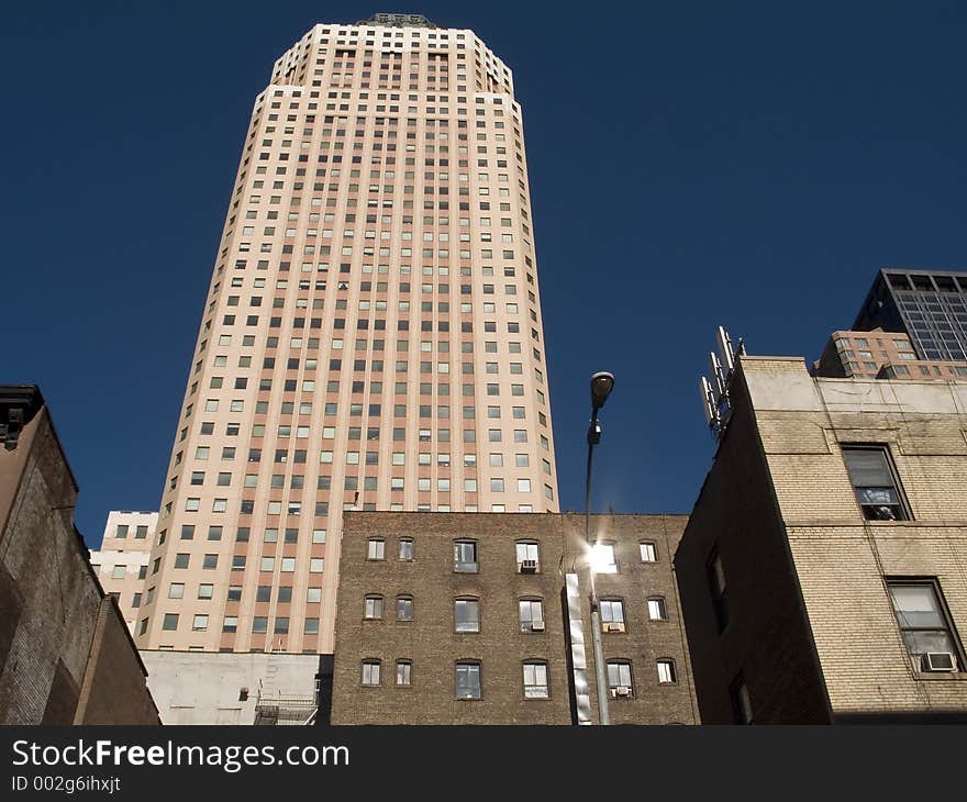 This is a shot of an apartment building in New York City against a rich blue sky. This is a shot of an apartment building in New York City against a rich blue sky.