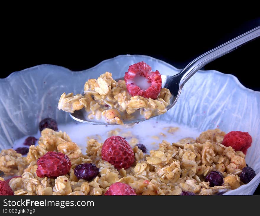 Bowl of cereal with milk dripping off spoon. Bowl of cereal with milk dripping off spoon