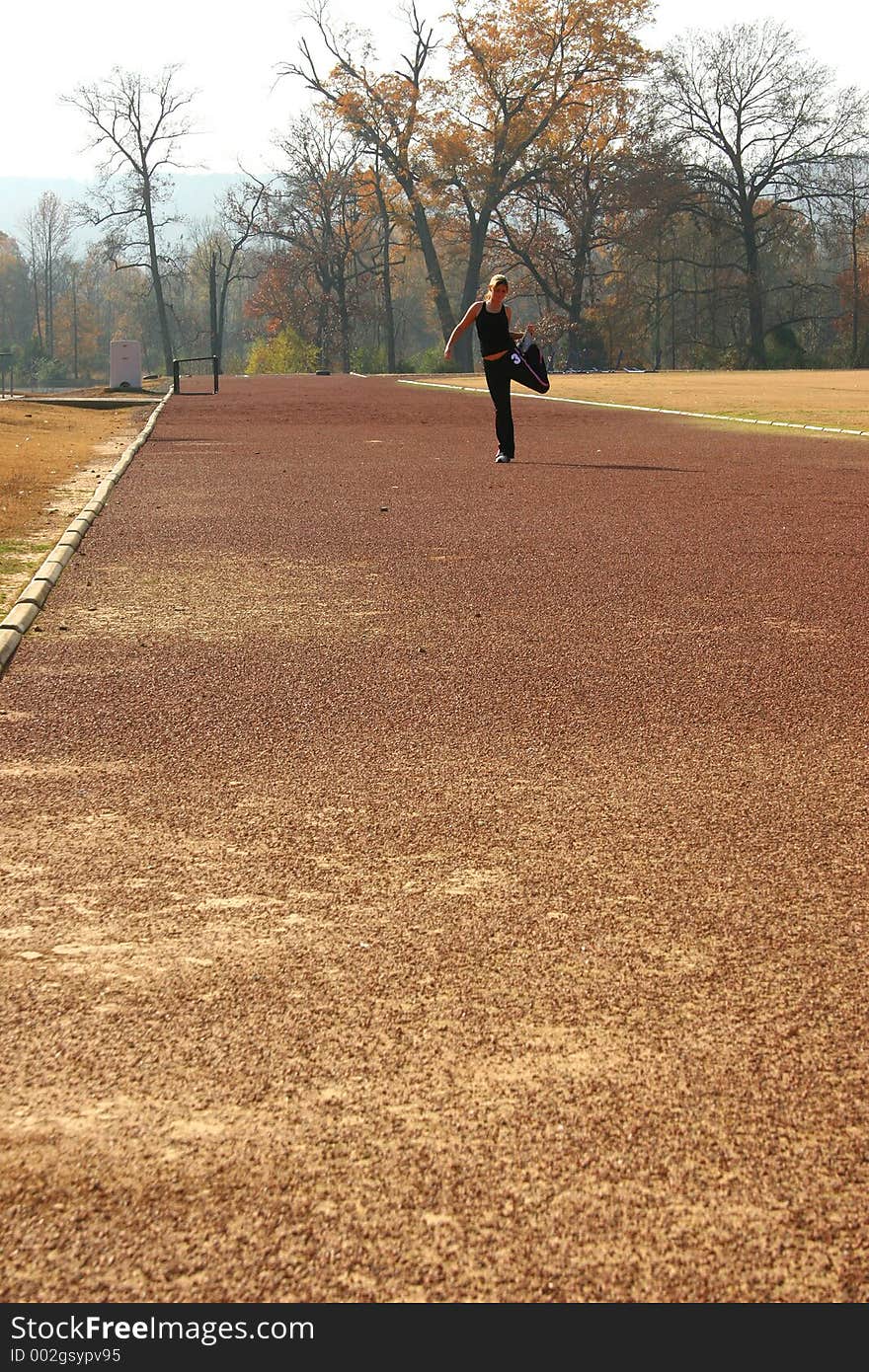 Athletic Young Woman Stretching at the Track