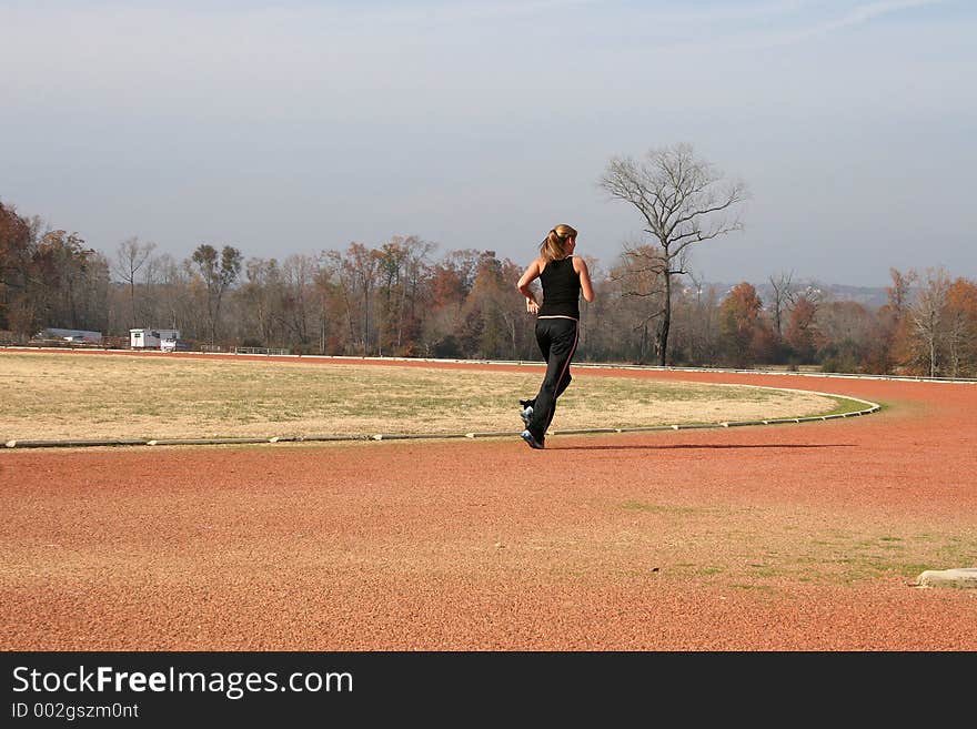 Athletic Young Woman Running at the Track