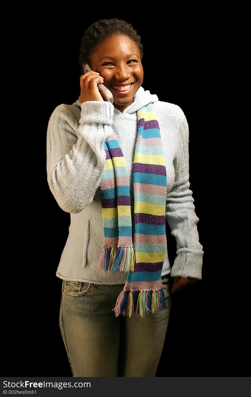 A teenage girl on a cell phone about to laugh. Isolated on a black background. A teenage girl on a cell phone about to laugh. Isolated on a black background.