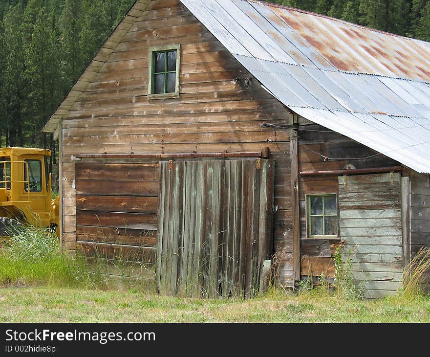 A new tractor sets next to an old barn. A new tractor sets next to an old barn.