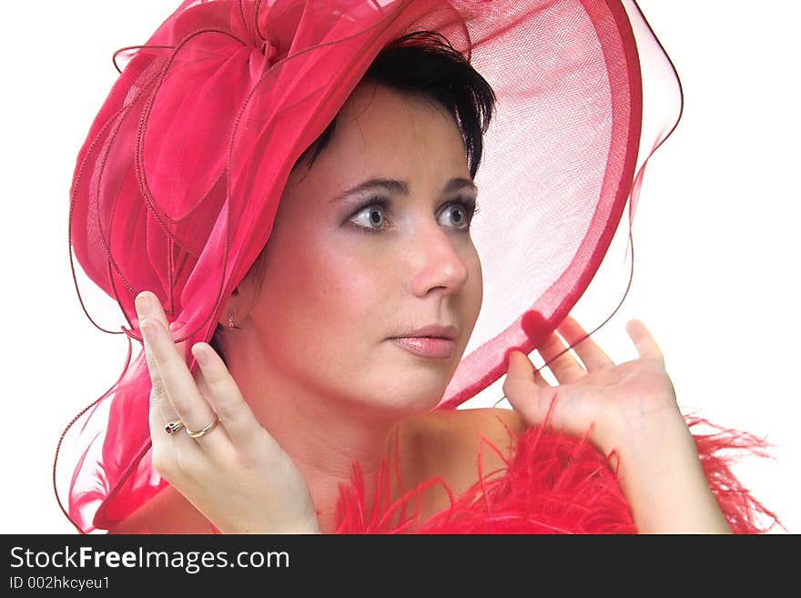 Portrait of a beautiful young woman wearing a red hat and feathered red boa over naked shoulders. Portrait of a beautiful young woman wearing a red hat and feathered red boa over naked shoulders